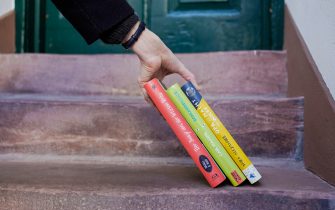 25 March 2020, Baden-Wuerttemberg, Heidelberg: Julia Sunderer, owner of the children's and youth bookshop "Murkelei", lays books on the stairs of a house entrance. She tries to save her shop for children's and young people's literature with a delivery service about the state of emergency of the Corona crisis. (to dpa-KORR: "Businesses against Corona: He who does not want to be delivered, delivers") Photo: Uwe Anspach/dpa (Heidelberg - 2020-03-25, Uwe Anspach / IPA) p.s. la foto e' utilizzabile nel rispetto del contesto in cui e' stata scattata, e senza intento diffamatorio del decoro delle persone rappresentate