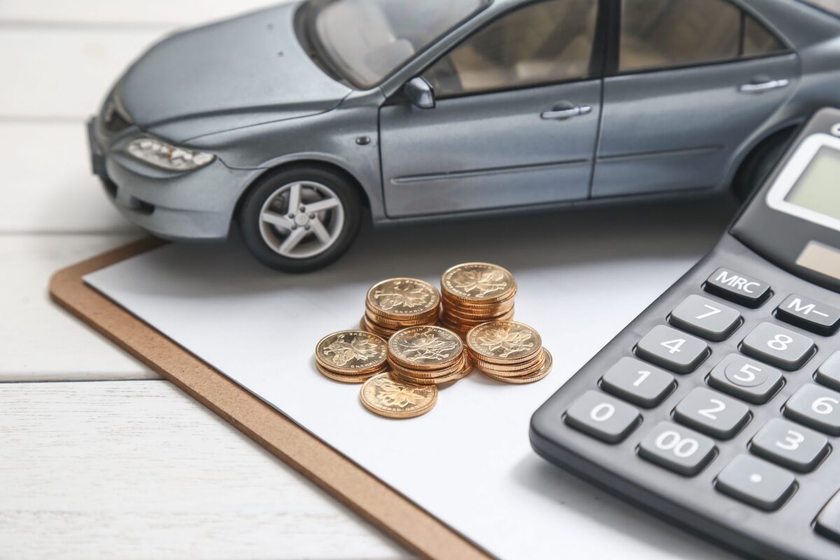 car-model-calculator-and-coins-on-white-table-min