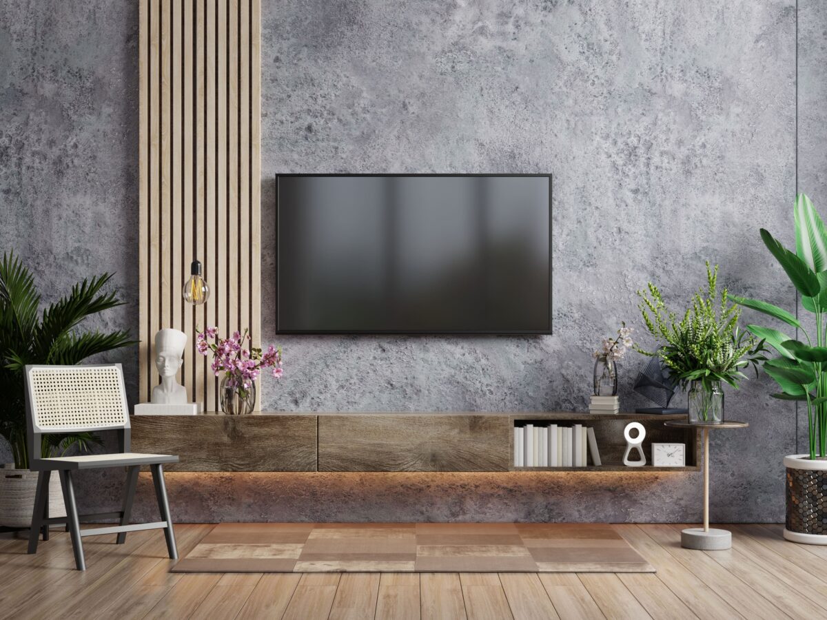a-tv-in-modern-living-room-with-armchair-and-plant-on-concrete-wall-background-3d-rendering-min